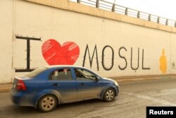 A car drives past graffiti in Mosul, Oct. 27, 2018.