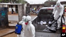 Wafanyakazi wa afya wakibeba maiti iliyotokana na ugonjwa wa Ebola