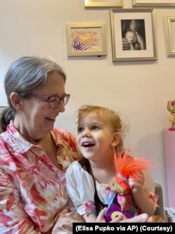 Mary Pupko sits with her granddaughter Evelyn. Pupko, a 64-year-old retired seamstress with multiple sclerosis, moved to Brooklyn from Seattle to be closer to her family. (Elisa Pupko via AP)