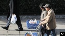 An elderly Chinese couple pushes carts load with groceries as they shop at a supermarket in Beijing, China, 11 Nov 2010