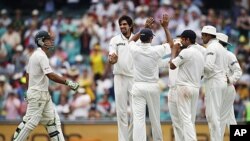 Indian players celebrate after Ishant Sharma (2nd L) took the wicket of Australia's Ricky Ponting (L) during the second test cricket match at the Sydney Cricket Ground, January 4, 2012.