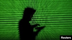 In this file photo, a mobile device user is shown next to a screen projection of binary code on March 28, 2018. (REUTERS/Dado Ruvic/Illustration)
