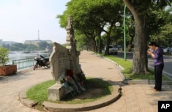 Una mujer brinda sus respetos en el monumento al fallecido senador estadounidense John McCain en Hanoi, Vietnam, el lunes, 27 de agosto de 2018.