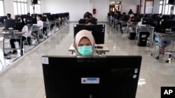 Seorang mahasiswi mengenakan masker saat mengikuti ujian masuk UPN Jakarta, Juli 2020. (foto: AP/Tatan)