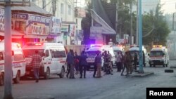 Bezbjednosne snage Somalije obezbeđuju mesto eksplozije automobila bombe, dok vozila hitne pomoći čekaju kako bi se ukazala ponoć povređenima u oblasti poznatoj kao Četvrti kilometar u Mogadišu, Somalija, 31. januara 2021. (RojtersS/Feisal Omar)