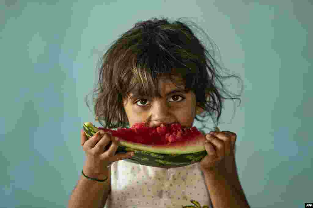 A girl eats watermelon at a school building where Syrians -- displaced from the area of Ras al-Ain by the Turkish offensive on the northeast -- are staying in the city of Hasakah.