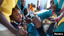 FILE - A child receives a meningitis vaccination at the community center in Al Neem camp for Internally Displaced People in El Daein, East Darfur, Oct. 8, 2012.