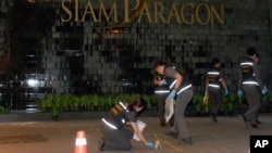 Thai police forensic officers investigate near the front of the Siam Paragon shopping mall, the site of a blast in Bangkok, Thailand, Feb. 1, 2015. 