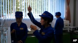 In this Oct. 22, 2018, photo, workers test samples of products for consistency at the factory lab at Songdowon General Foodstuffs Factory in Wonsan, North Korea.