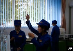 In this Oct. 22, 2018, photo, workers test samples of products for consistency at the factory lab at Songdowon General Foodstuffs Factory in Wonsan, North Korea.