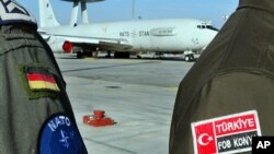 FILE - A Turkish NATO MP, right, guards with a German crew member a plane based at the Forward Operation Base in Konya, Turkey, March 13, 2003.