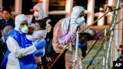 Rescuers help children disembark in the Sicilian harbor of Pozzallo, Italy, April 20, 2015. About 100 migrants, including 28 children, were rescued on Sunday by a merchant vessel in the Sicilian Strait while they were trying to cross.