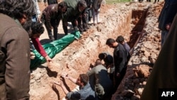 Syria -- Syrians dig a grave to bury the bodies of victims of a a suspected toxic gas attack in Khan Sheikhun, a nearby rebel-held town in Syria’s northwestern Idlib province, April 5, 2017