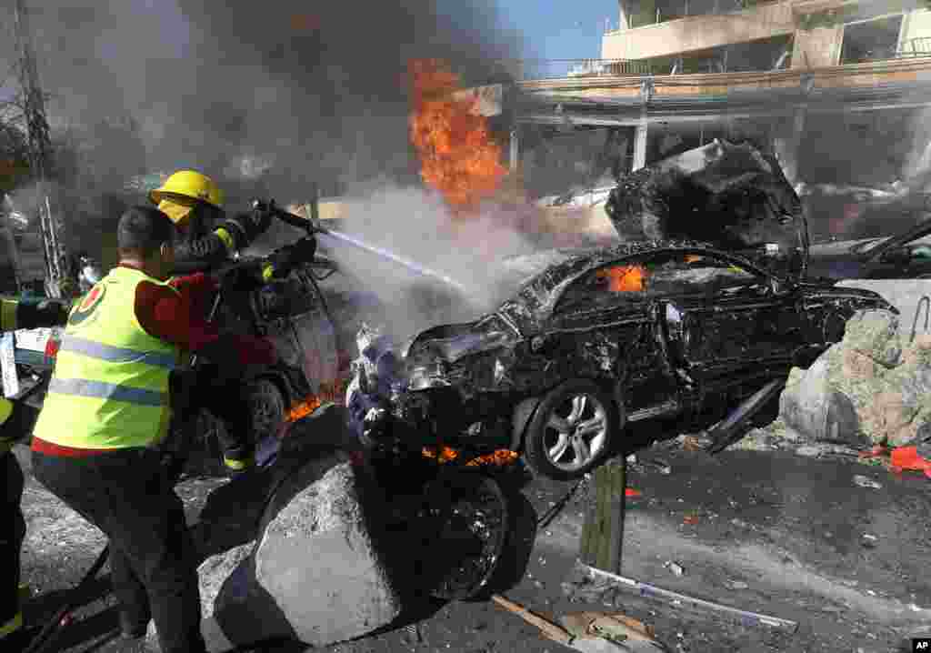 Lebanese firefighters extinguish a burning car at the site of an explosion near the Kuwaiti Embassy and Iran&#39;s cultural center, in the suburb of Beir Hassan, Beirut, Lebanon, Feb. 19, 2014. 
