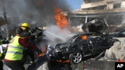Lebanese firefighters extinguish a burning car at the site of an explosion near the Kuwaiti Embassy and Iran's cultural center, in the suburb of Beir Hassan, Beirut, Feb. 19, 2014. 