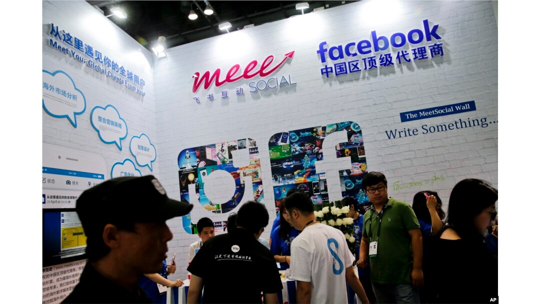 FILE - Visitors gather at a social network company booth which enable people to connect global clients during the 2016 Global Mobile Internet Conference (GMIC) in Beijing.