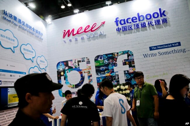 FILE - Visitors gather at a social network company booth which enable people to connect global clients during the 2016 Global Mobile Internet Conference (GMIC) in Beijing.
