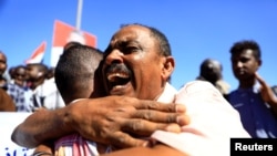 Civiles sudaneses se abrazan después de la sentencia de muerte de 29 miembros del servicio nacional de inteligencia por el asesinato de un maestro detenido en febrero durante las protestas que llevaron al derrocamiento del ex presidente Omar al-Bashir. Foto REUTERS.