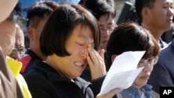 An unidentified family member of passengers aboard the sunken ferry Sewol caries as she demands maximum punishment to be sentenced on the crew members of the ferry during their trial at Gwangju District Court in Gwangju, South Korea, Oct. 27, 2014. 
