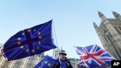An anti Brexit demonstrator waves EU and British flags in Westminster in London, Dec. 8, 2017. 