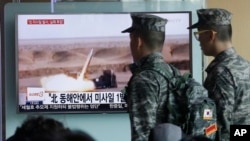 South Korean army soldiers pass by a TV news program showing a file footage of a missile launch conducted by North Korea at Seoul Railway Station in Seoul, South Korea, Friday, April 15, 2016.