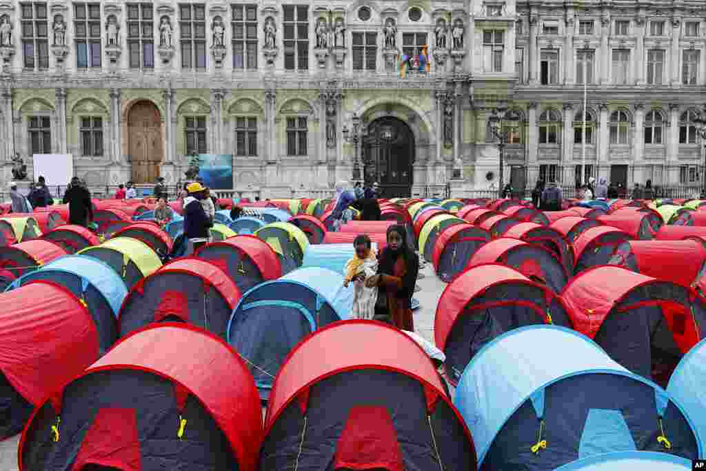 A woman migrant holds her baby in a makeshift camp set up outside the Paris town hall. More than 300 migrants set up some 200 tents outside the town hall to draw attention to their living conditions and to demand accommodation.