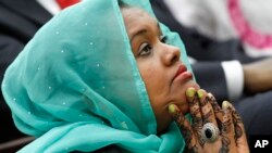 Deeqo Jibril of Boston, the founder of the Somali Community and Cultural Association, listens as President Barack Obama speaks at the White House Summit on Countering Violent Extremism, Feb. 18, 2015.