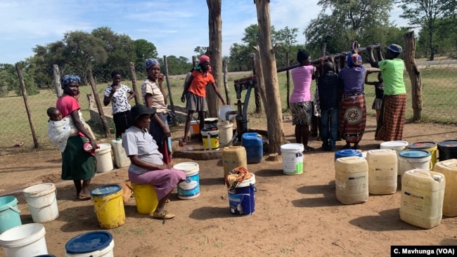 Women wait to collect water at a borehole in Zimbabwe’s Tsholotsho District, April 18, 2019.