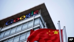 FILE - The Chinese flag is seen near the Google sign at the Google china headquarters in Beijing, China.