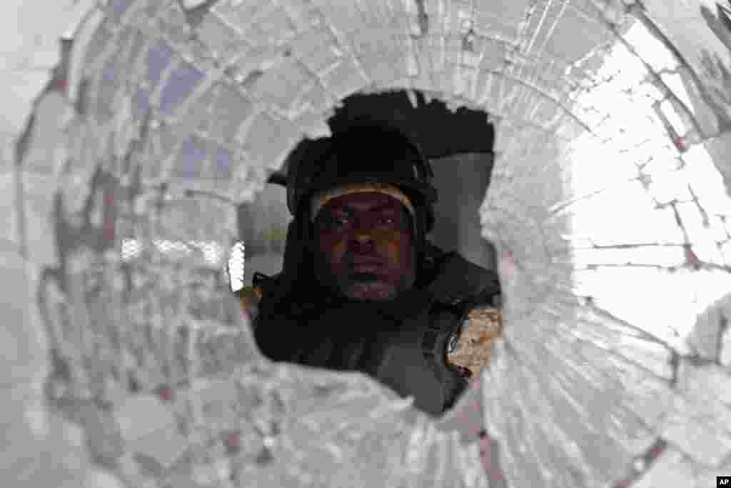 Polis zabiti etirazçlıar tərəfindən qabaq pəncərəsi qırılmış maşını sürür. Port-au-Prince, Haiti, 21 noyabr, 2016.