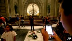 Orang-orang berdiri di sekitar makam mantan diktator Spanyol Francisco Franco di dalam basilika di luar Madrid, 24 Agustus 2018. (Foto: AP)