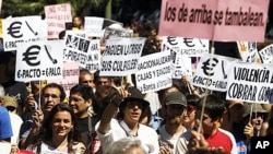 Demonstrators holding placards march towards the building of the Spanish parliament in Madrid, June 19, 2011