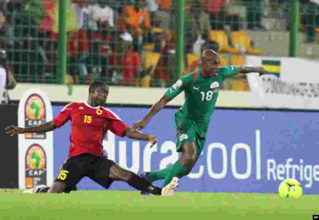 Qulami Miguel Geraldo vai à bola com Kabore Charles do Burkina Faso durante o primeiro jogo das Palancas Negras, no CAN 2012, no Estádio de Malabo, a 22 de Janeiro