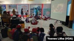 Pengunjung pameran menyaksikan pemutaran film dokumenter yang berisi penjelasan mengenai fenomena gempa bumi, tsunami dan likuefaksi, 8 Oktober 2019. (Foto: VOA/Yoanes Litha)