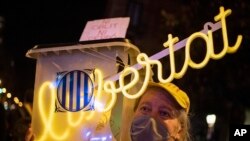 FILE - A protester holds a ballot box with writing in Catalan reading 'neither forget nor forgive' and 'freedom' during a demonstration to mark the fourth anniversary of a failed independence referendum in Barcelona, Oct. 1, 2021.