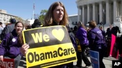 Tenant une pancarte disant «We Love ObamaCare», les partisans de la réforme des soins de santé devant la Cour suprême à Washington, le 27 mars 2012