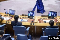 FILE - Shaharzad Akbar (on screens), chairperson of the Afghanistan Independent Human Rights Commission, addresses a Security Council meeting, Aug. 6, 2021.