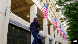 도널드 트럼프 미국 대통령이 제임스 코미 연방수사국(FBI) 국장을 해임한 다음날인 지난 10일 워싱턴 시내에 있는 FBI 본부 건물 앞으로 카메라를 맨 취재기자가 지나고 있다. 