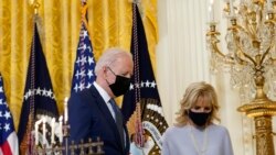 Presiden AS Joe Biden dan Ibu Negara Jill Biden berjalan melewati menorah yang telah dinyalakan dalam perayaan Hanukkah di Ruang Timur, Gedung Putih, di Washington, pada 1 Desember 2021. (Foto: AP/Susan Walsh)