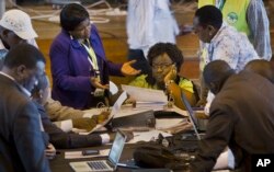 FILE - In this March 6, 2013 photo, official representatives of the various political parties and electoral workers discuss while reviewing newly received results, at the National Tallying Center in Nairobi, Kenya.