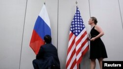 FILE - Staffers install U.S. and Russian flags as part of a bilateral meeting, Aug. 26, 2016. Theoretically, U.S. President Donald Trump and Russian President Vladimir Putin would have an opportunity to meet Friday in Vietnam but it's not clear whether the two will talk face-to-face.