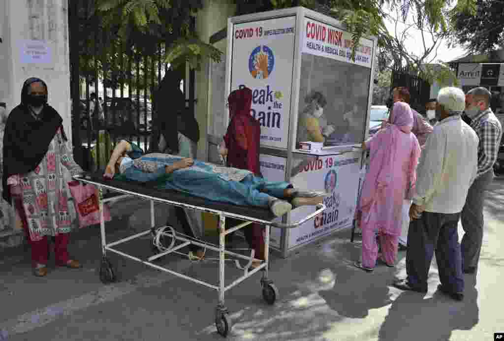 People wait to test for COVID-19 at a government hospital in Jammu, India, Monday, Oct.5, 2020. India, the second worst-affected nation in the world after the United States, is witnessing a sustained decline in new coronavirus infections and active virus cases have remained below the million mark for 14 consecutive days. (AP Photo/Channi Anand)