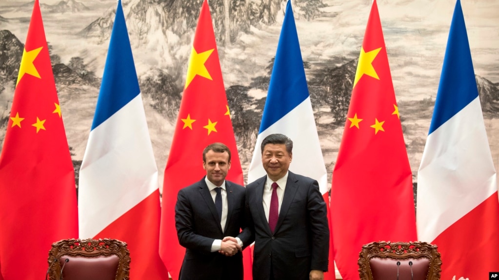 French President Emmanuel Macron, left, and Chinese President Xi Jinping shake hands after a joint press briefing at the Great Hall of the People in Beijing, Tuesday, Jan. 9, 2018.