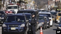 Police direct cars to gas pumps outside a gas station in the Brooklyn borough of New York, November 9, 2012.
