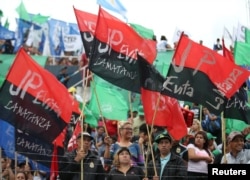 People hold flags during an anti-capitalist meeting at a local stadium, ahead of the Group of 20 gathering, in Buenos Aires, Argentina, Nov. 27, 2018.