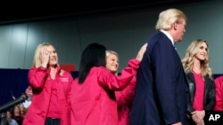 Republican presidential candidate Donald Trump stands on stage with female supporters during a campaign rally in Charlotte, North Carolina, Oct. 14, 2016.