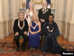 Kennedy Center Honorees (L-R, standing) actress and singer Rita Moreno, filmmaker George Lucas, (L-R, seated) Japanese conductor Seiji Ozawa, singer-songwriter Carole King and actress Cicely Tyson gather for a group photo after a gala dinner at the U.S. State Department in Washington, Dec. 5, 2015.