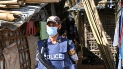 FILE - A member of the Armed Police Battalion stands guard in October 2021 near the office of top community Rohingya leader and activist Mohib Ullah, who was shot dead by gunmen in late September, at Kutupalong refugee camp in Ukhia.