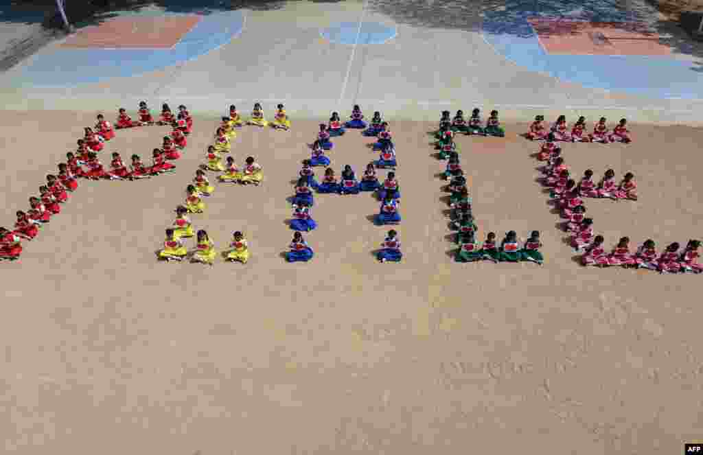 Indian students of Saint Francis Girls High School form the word "peace" as they participate in a 'Non-violence and Peace' rally in Secunderabad, on the 67th anniversary of Mahatma Gandhi's assassination. 