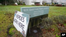 A sign that reads 'Heroes Work Here' is displayed outside the Washington State Dept. of Health's Public Health Laboratory on Dec. 7, 2021, in Shoreline, Wash.